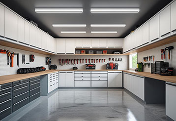 Custom garage storage cabinets, workbenches, and wall-mounted tool organization in a clean, modern garage, showing the results of a custom garage solution in Aliso Viejo