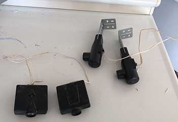 Comparison of new and obsolete garage door safety sensors during professional repair in Laguna Hills CA